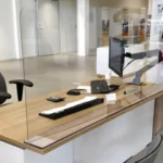 smittevegg og skillevegg montert på et skrivebord hos en bilforhandler